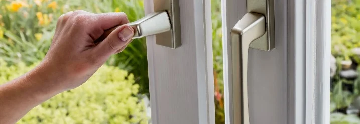 Hand öffnet Balkontür mit Fenstergriff